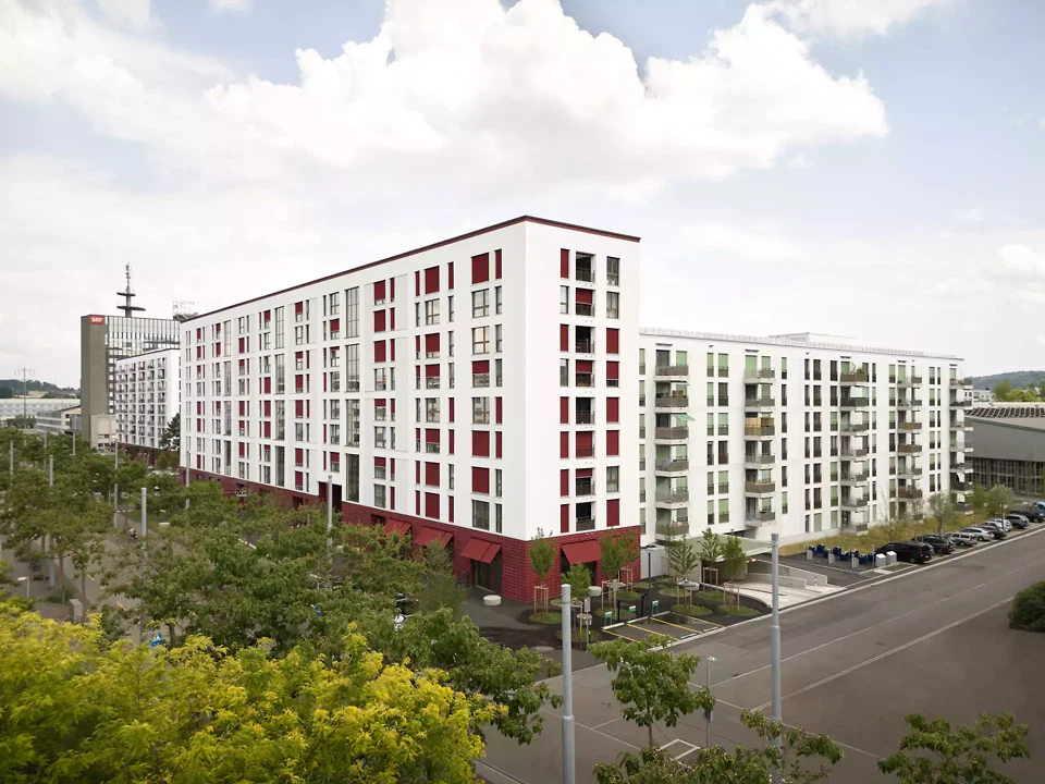 Cette partie du bâtiment, haute de neuf étages, fait le lien entre les immeubles de grande hauteur situés à l'ouest et au sud du lotissement, sans faire d'ombre au Leutschenpark situé au nord