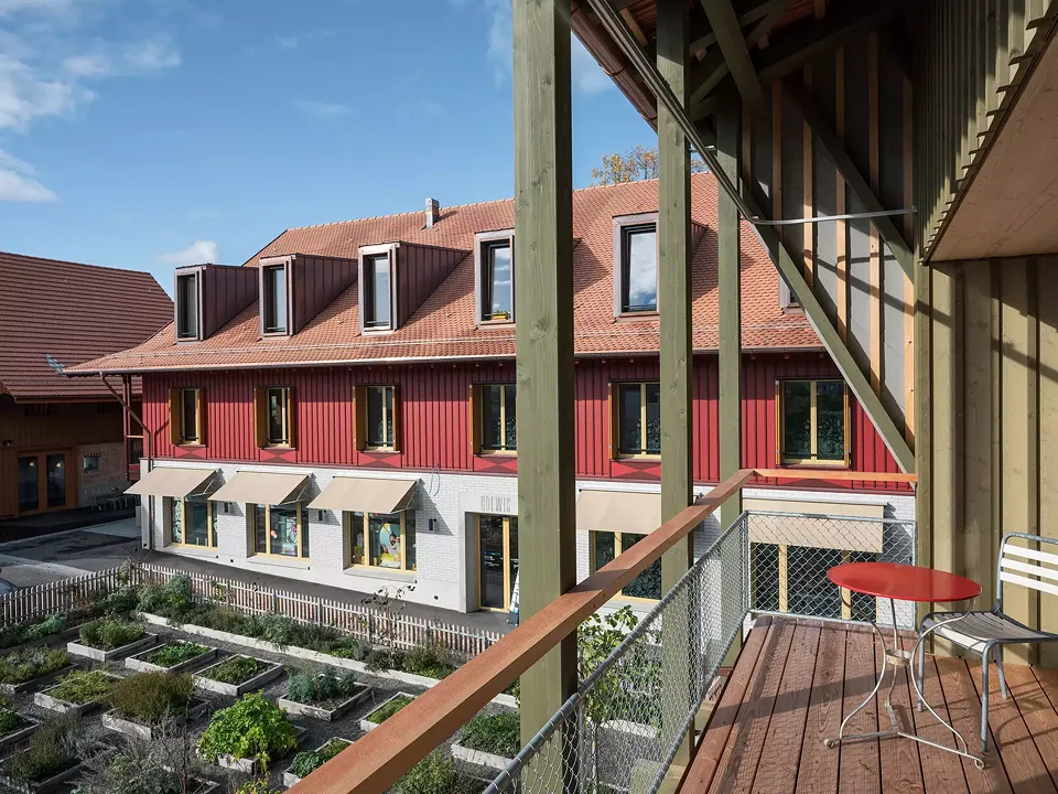 Blick vom Laubenhaus zum Gesundheitszentrum über den Kräutergarten hinweg