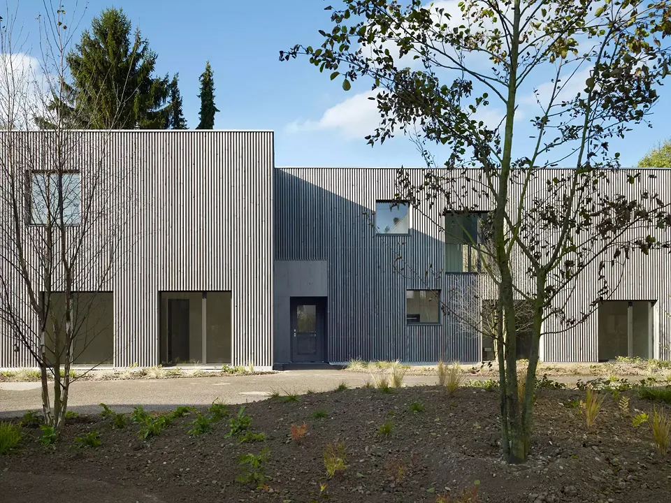 Fassade aus vorvergrauten Rundhölzern