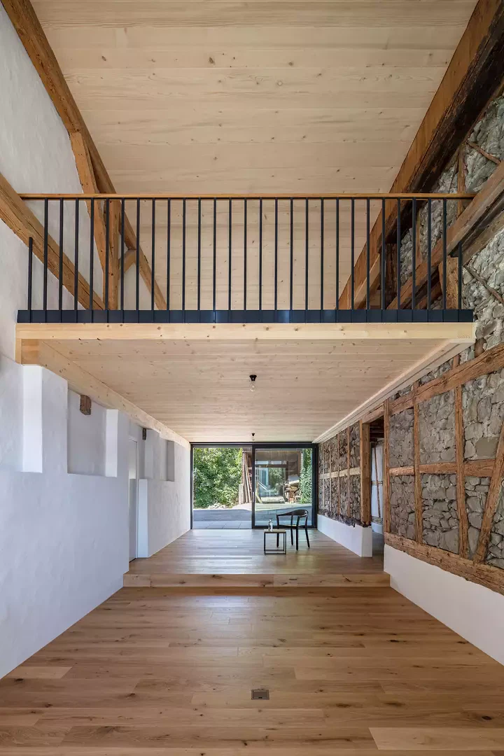 Ehemaliges Tenn als Wohnraum mit offener Galerie, freiliegendes Holzriegelwerk und Bruchsteinmauerwerk.