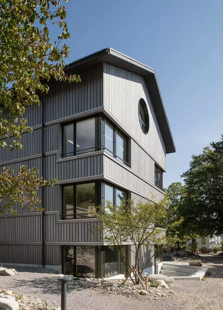 La façade en bois lasurée de gris anticipe le vieillissement.