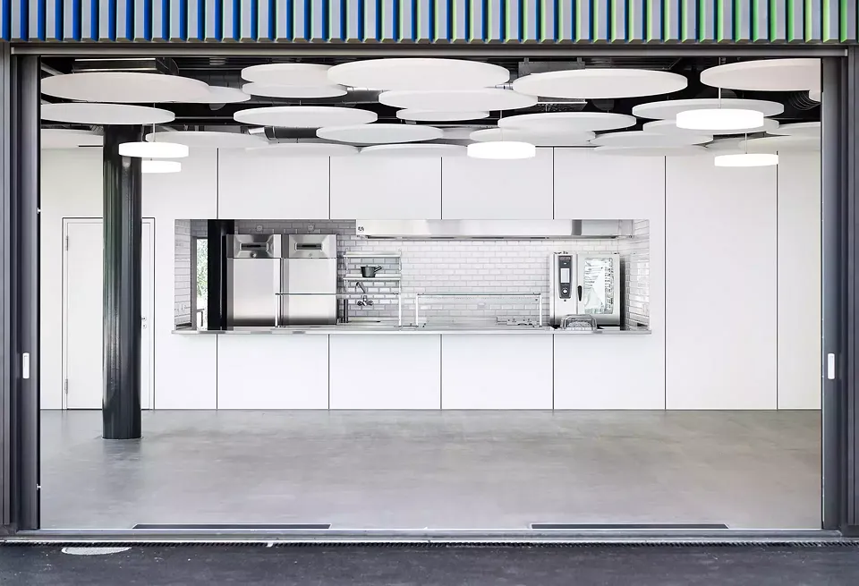 Durch das Verkleinern des Eingangsbereichs in einen der Pavillons konnte ein neues Volumen hinzugefügt werden. In diesem einfachen und  hellen Raum befindet sich  das neue Schulrestaurant. Es ist mit runden Akustikplatten ausgestattet.