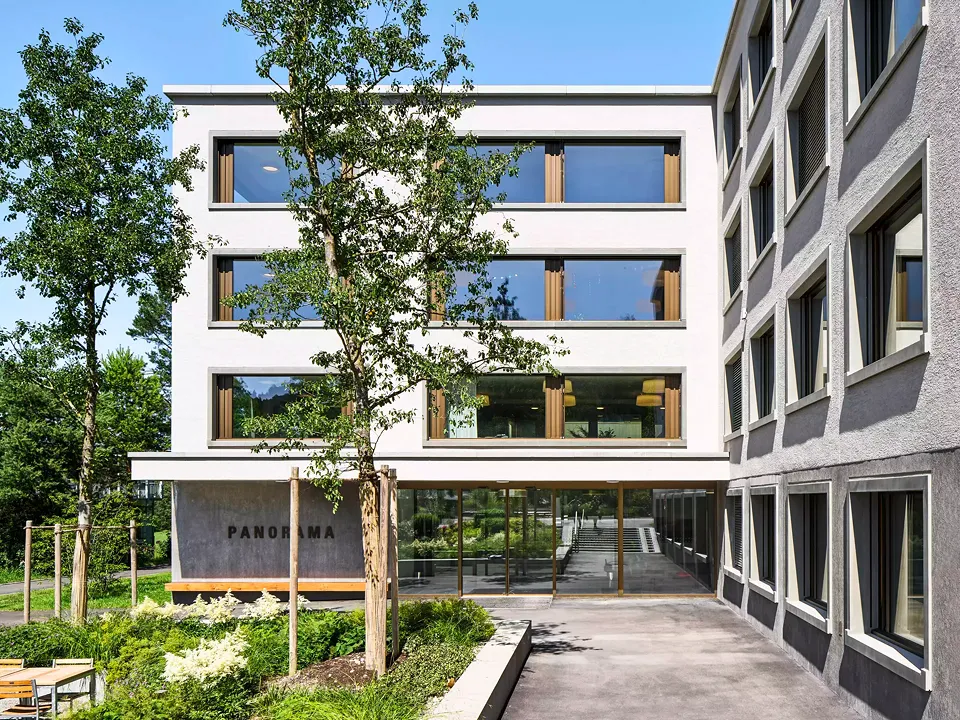 Für Patienten und Besucher ist der ruhige Hof ein Ort zum Verweilen. Unter einem Vordach ist eine lange Bank in massiver Eiche an der strukturierten Betonwand angebracht.