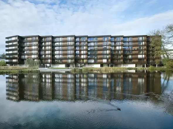Der sechsgeschossigen Baukörper liegt direkt am Weiher