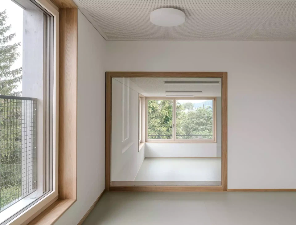 Salle de groupe légèrement surélevée avec vue traversante sur la salle de classe