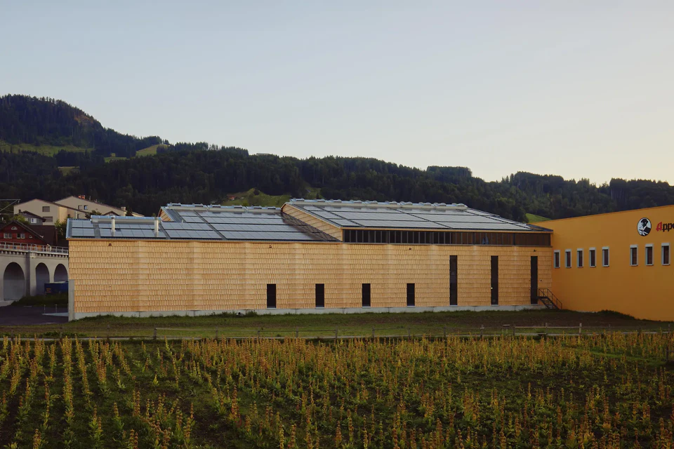 Blick über das Enzianfeld auf die Nordfassade und den Bestandbau