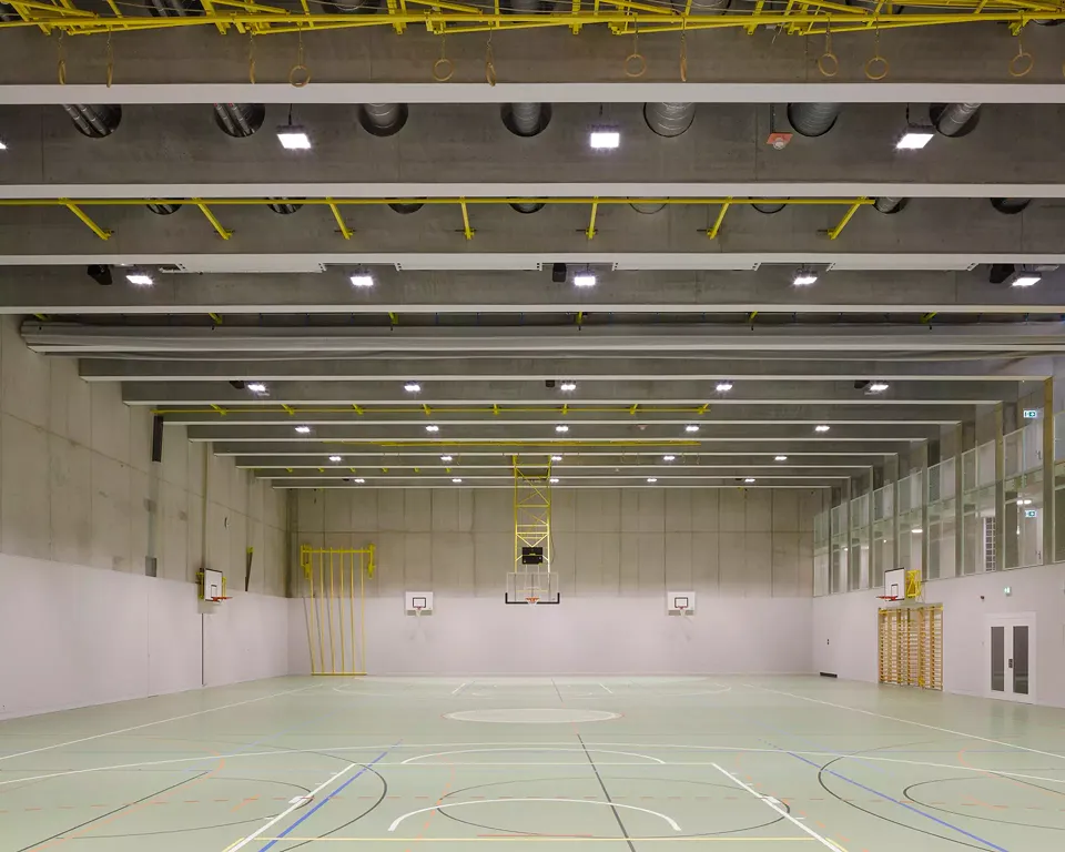 Durch einen hohen Galerieraum wird ein Blickbezug aus der eingegrabenen Sporthalle zur Aussenwelt hergestellt. 