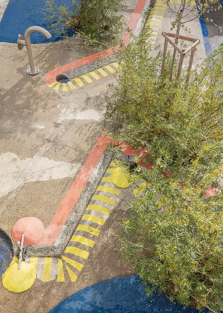 réseau de canaux découpés dans la chape béton du bassin existant et jeux d'eau. Saules et peupliers s'enracinent dans les fosses de plantations carottés dans la structure béton.  