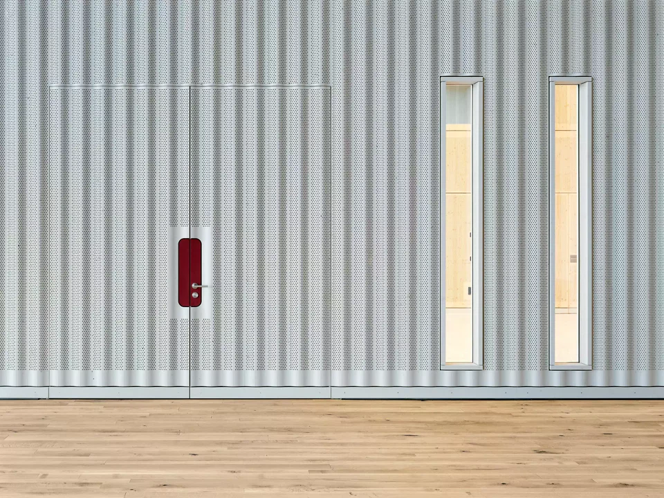 Vorhangartige Trennwand zwischen Foyer und Mehrzweckhalle, flexibel und akustisch wirksam