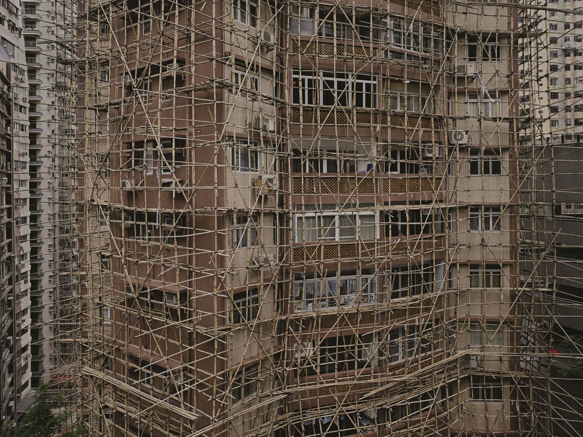 Ein Bambusgerüst umgibt ein Hochhaus in Hongkong. | Foto © Peter Steinhauer Peter Steinhauer