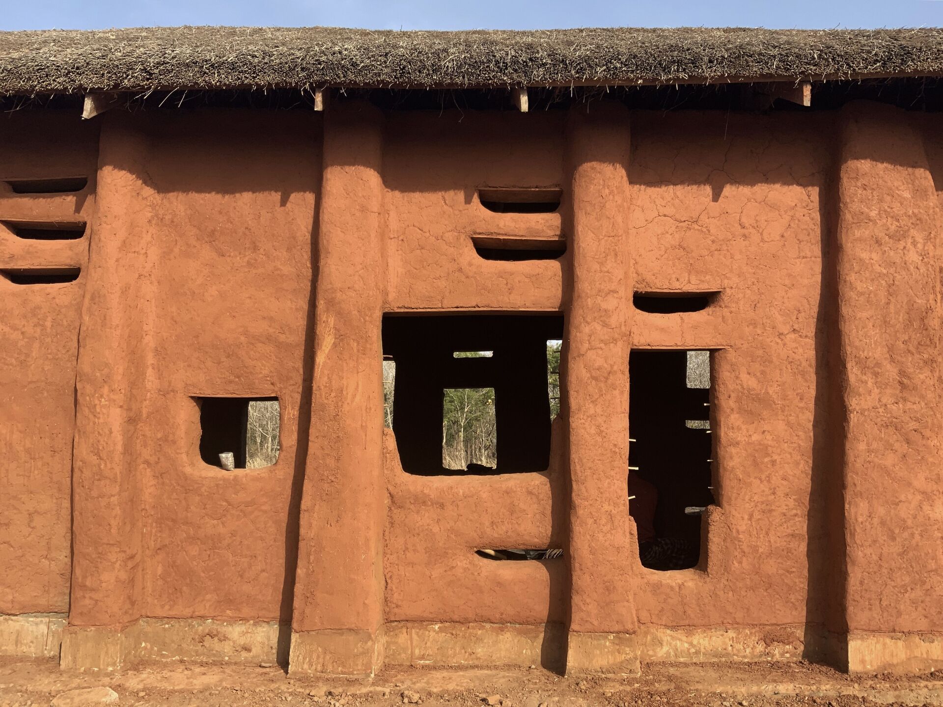 Comme sorti de terre: le premier bâtiment scolaire du campus de Tatale (Ghana), construit en 2023, se présente dans un rouge chaud, correspondant à la teinte de la terre locale. | Photo © Studio Anna Heringer Comme sorti de terre: le premier bâtiment scolaire du campus de Tatale (Ghana), construit en 2023, se présente dans un rouge chaud, correspondant à la teinte de la terre locale. | Photo © Studio Anna Heringer