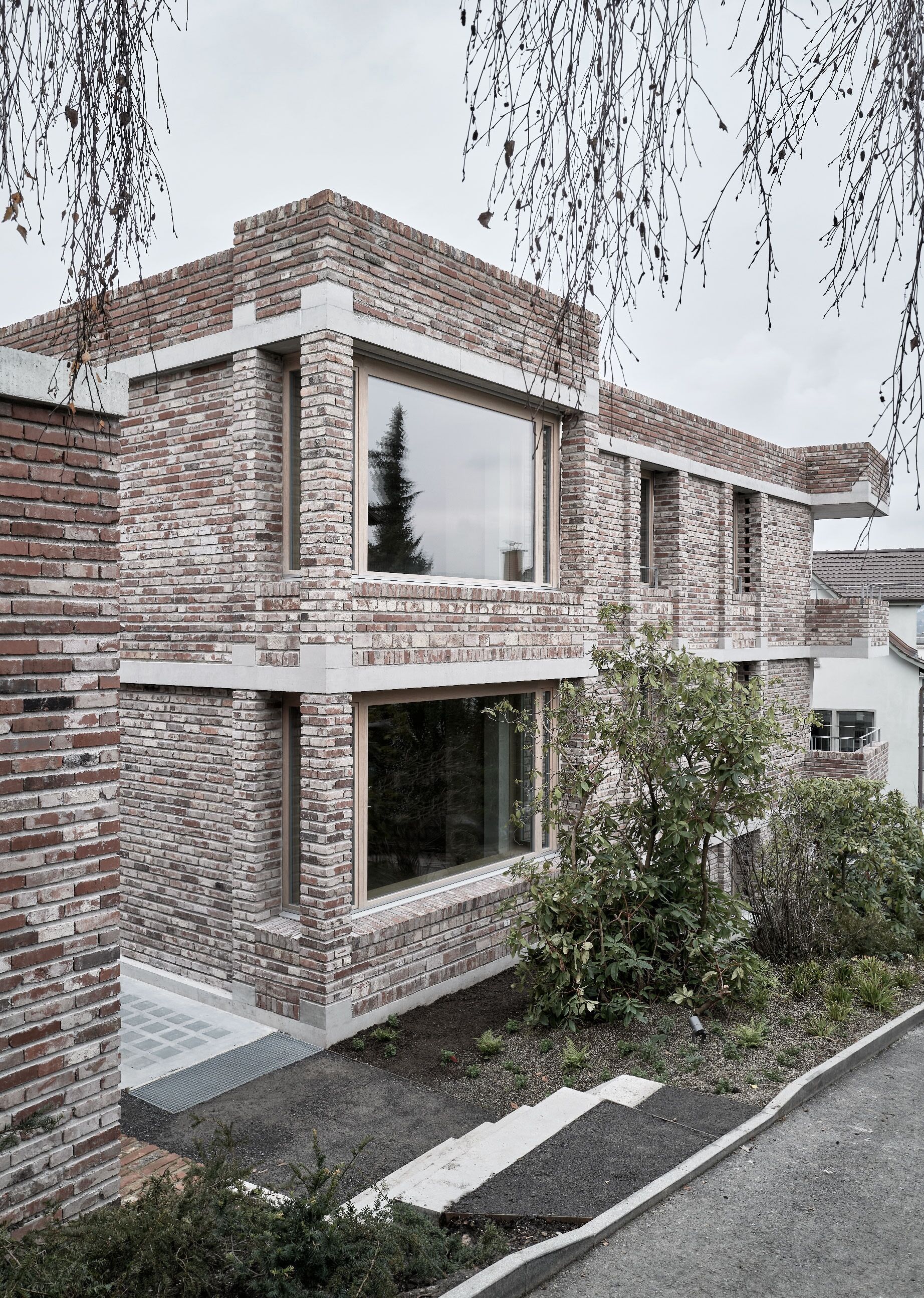 Für das Mehrfamilienhaus in Kilchberg entwickelten Boltshauser Architekten ein neues Zweischalenmauerwerk. Die Fassade besteht aus wiederverwendeten Vollbacksteinen eines Abbruchobjekts, während die Innenwände aus ungebrannten Lehmsteinen konstruiert sind.| Foto: Kuster Frey Kuster Frey
