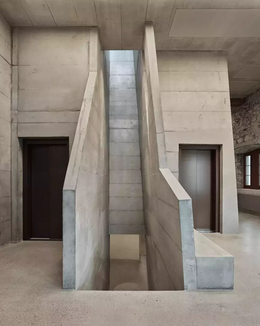 Bruchsteinmauerwerk, gestockter und glatter Beton, historische Holzelemente – im Treppenhaus treten verschiedene Materialien beziehungsweise Oberflächen in einen Dialog. | Foto: Valentin Jeck Bruchsteinmauerwerk, gestockter und glatter Beton, historische Holzelemente – im Treppenhaus treten verschiedene Materialien beziehungsweise Oberflächen in einen Dialog. | Foto: Valentin Jeck