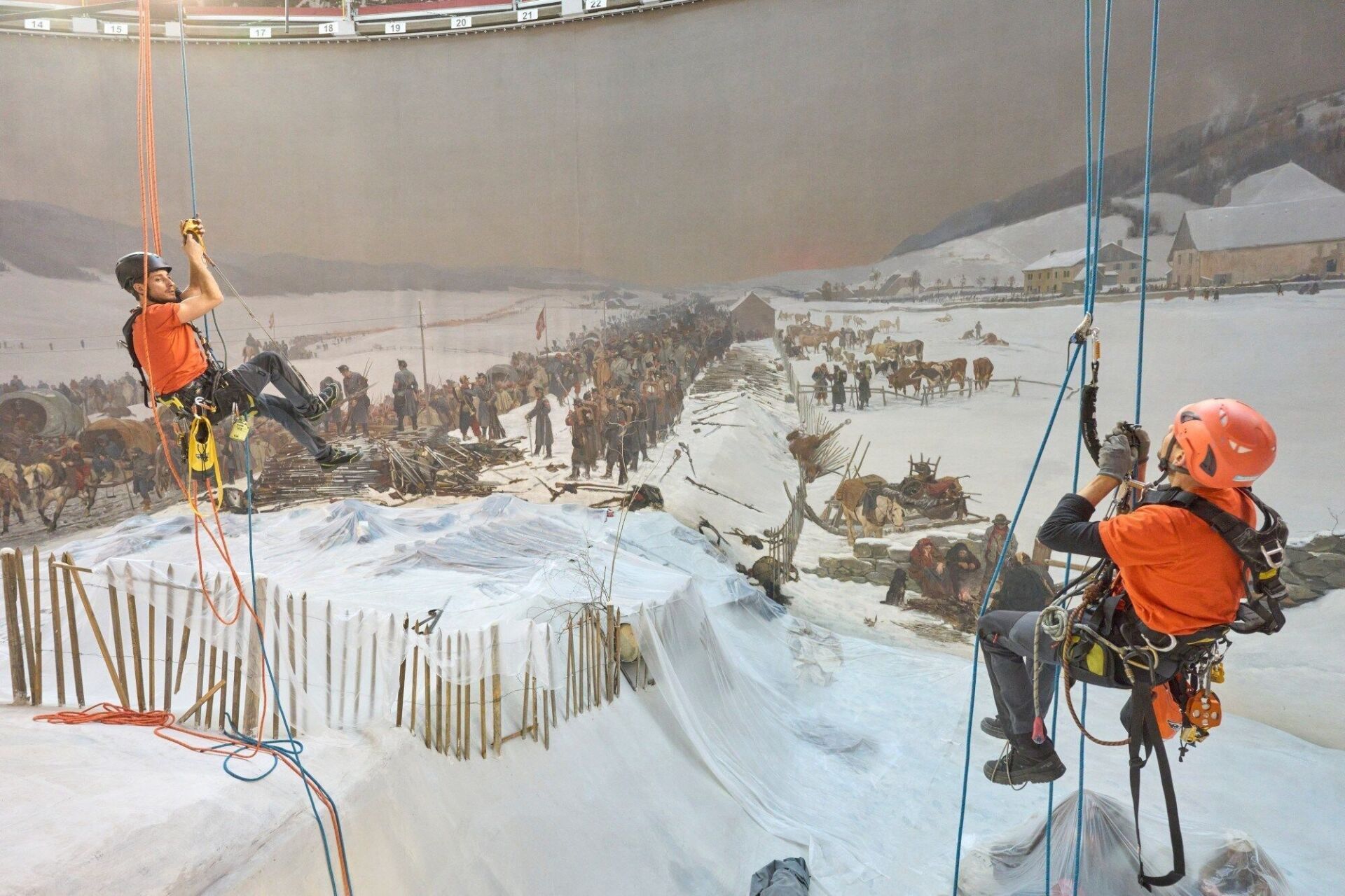 Des cordistes s’activent déjà à poser les nouveaux voiles solaires et l’appareil optique qui mettent la peinture circulaire en valeur. | Photo: Gabriel Ammon / AURA © Bourbaki Panorama Des cordistes s’activent déjà à poser les nouveaux voiles solaires et l’appareil optique qui mettent la peinture circulaire en valeur. | Photo: Gabriel Ammon / AURA © Bourbaki Panorama