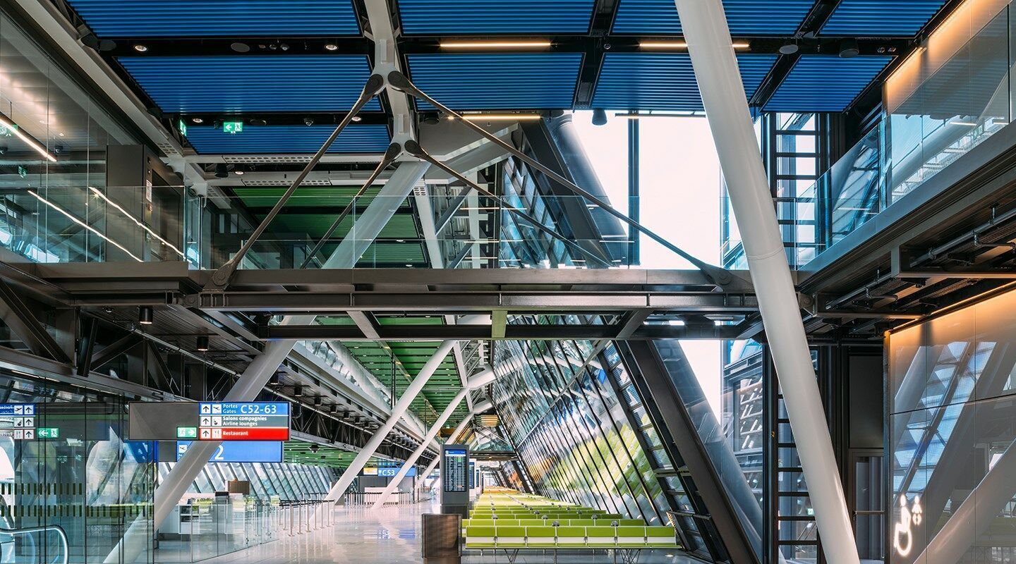 L'alternance des couleurs du plafond en baffle activé par le climat du terminal Aile Est de Genève Aéroport donne une impression de continuité et de changement, mais facilite également l'orientation des passagers grâce à un marquage de couleur concis. © Photo: Joas Souza (joas.co.uk) L'alternance des couleurs du plafond en baffle activé par le climat du terminal Aile Est de Genève Aéroport donne une impression de continuité et de changement, mais facilite également l'orientation des passagers grâce à un marquage de couleur concis. © Photo: Joas Souza (joas.co.uk)