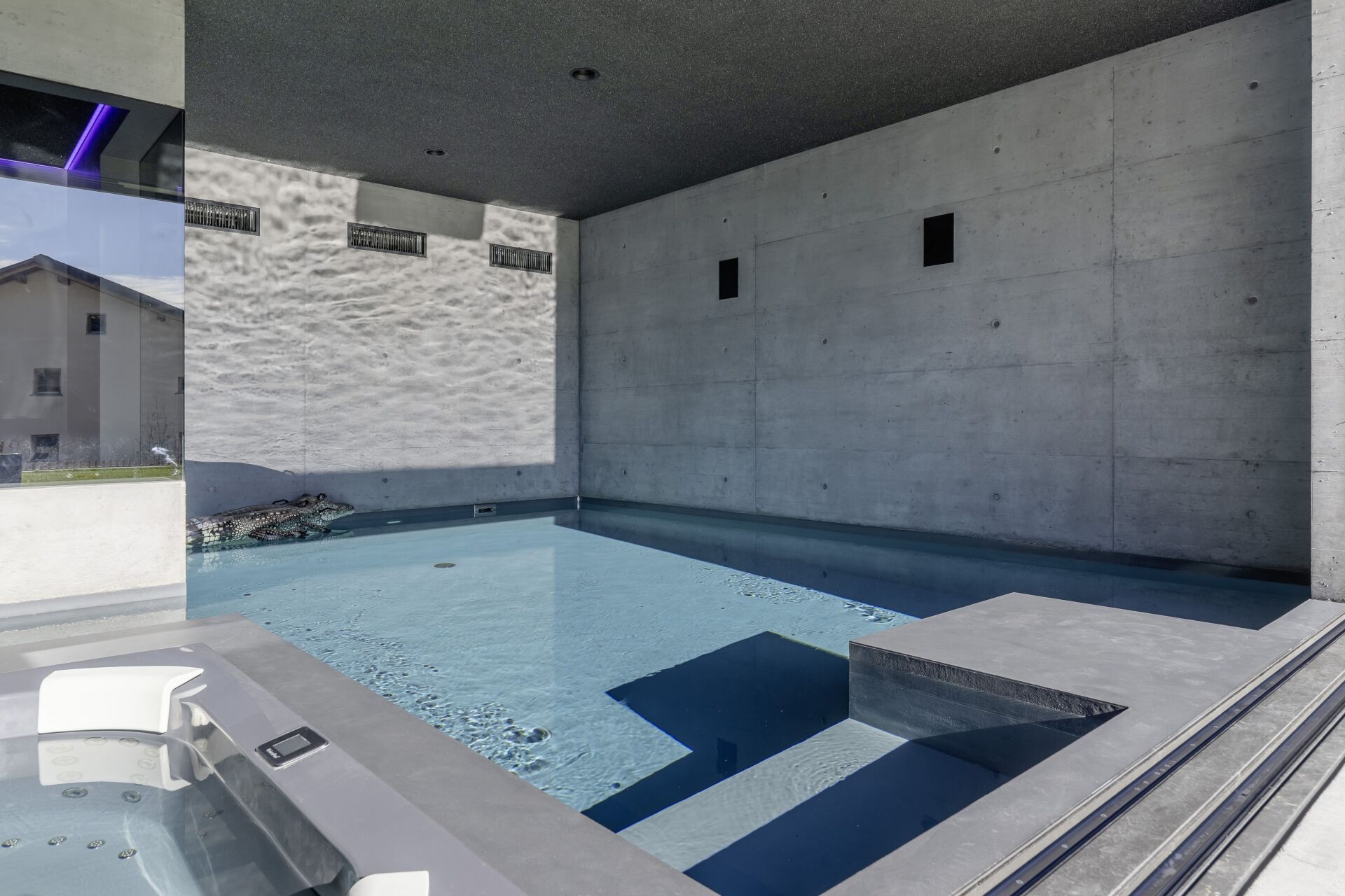 Des reflets de lumière dansent sur les murs en béton apparent et donnent à la piscine intérieure une atmosphère particulière. | Photo © Apix AG Apix AG